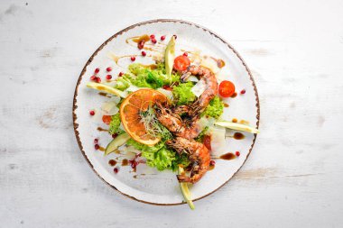 Karides ve avokado ile salata. Tabakta. Rustik tarz. Üst te. Metniniz için boş alan.