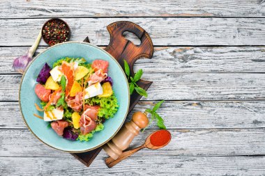 Brie peynirli jamon salatası ve portakal peyniri. Tabakta. Rustik tarz. Üst te. Metniniz için boş alan.