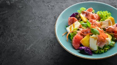 Brie peynirli jamon salatası ve portakal peyniri. Tabakta. Rustik tarz. Üst te. Metniniz için boş alan.