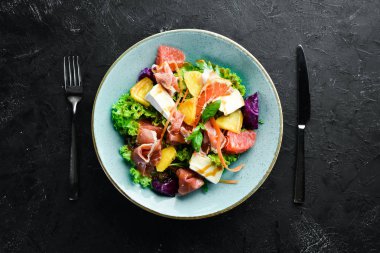 Brie peynirli jamon salatası ve portakal peyniri. Tabakta. Rustik tarz. Üst te. Metniniz için boş alan.