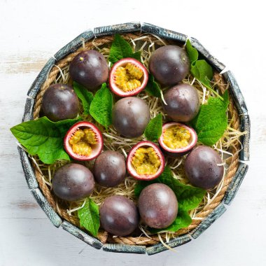 Ahşap kutu yaprakları ile taze tutku meyve. Tropikal meyveler. Üst görünüm. Metin için boş alan.