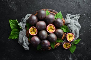 Siyah bir arka plan üzerinde yaprakları ile Passion meyve. Tropikal Meyveler. Üst te. Metin için boş alan.