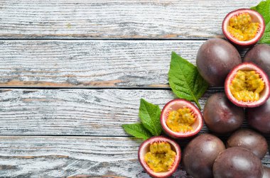 Beyaz ahşap arka plan üzerinde bir yaprak ile Passion meyve. Tropikal Meyveler. Üst te. Metin için boş alan.