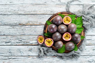 Beyaz ahşap arka plan üzerinde bir yaprak ile Passion meyve. Tropikal Meyveler. Üst te. Metin için boş alan.