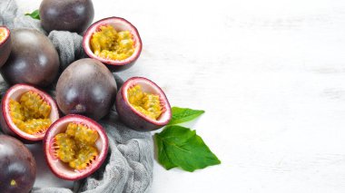 Beyaz ahşap arka plan üzerinde bir yaprak ile Passion meyve. Tropikal Meyveler. Üst te. Metin için boş alan.