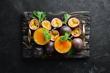 Tutku meyve suyu ve meyve siyah bir arka plan üzerinde. Tropikal Meyveler. Üst te. Metin için boş alan.