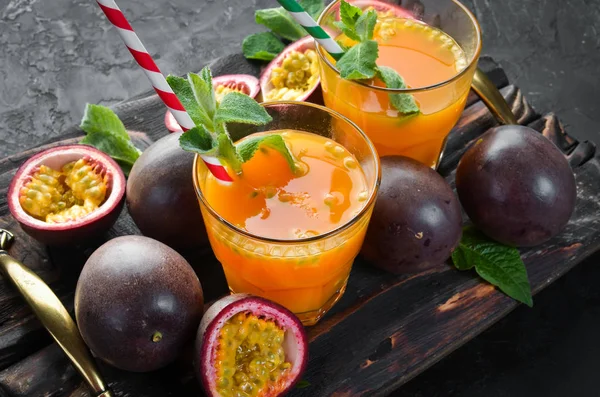 Passion fruits juice and fruits on a wooden background. Tropical Fruits.