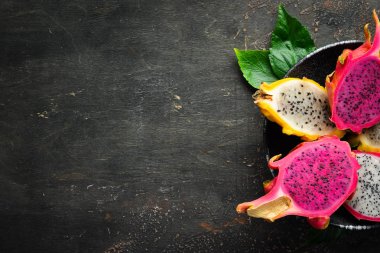 Siyah arka planda taze ejderha meyve. Tropikal meyveler. Üst görünüm. Metin için boş alan.