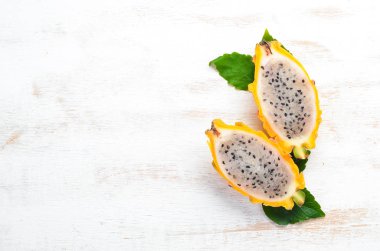 Beyaz ahşap arka plan üzerinde Sarı Ejderha Meyve. Pitahaya Tropikal Meyveler. Üst te. Metin için boş alan.