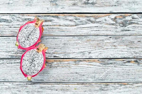 Fruit dragon on a white wooden background. Pitahaya Tropical Fruits. Top view. Free space for text.