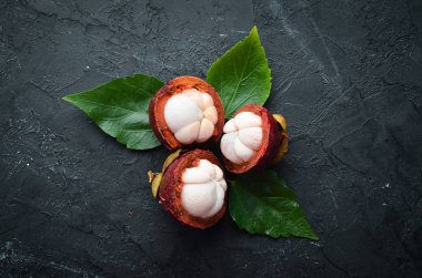 Siyah taş arka plan üzerinde bir yaprak ile Mangosteen. Tropikal Meyveler. Üst te. Metin için boş alan.