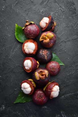 Siyah taş arka plan üzerinde bir yaprak ile Mangosteen. Tropikal Meyveler. Üst te. Metin için boş alan.