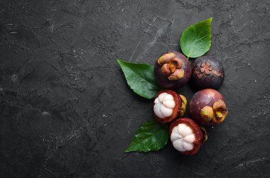 Siyah taş arka plan üzerinde bir yaprak ile Mangosteen. Tropikal Meyveler. Üst te. Metin için boş alan.