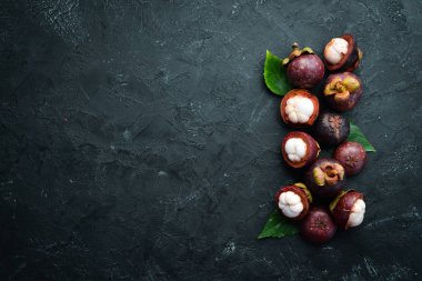 Siyah taş arka plan üzerinde bir yaprak ile Mangosteen. Tropikal Meyveler. Üst te. Metin için boş alan.