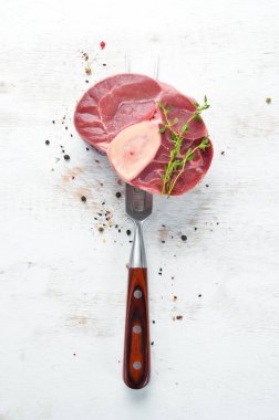 Beyaz bir arka plan üzerinde baharat ve otlar ile Ham taze çapraz kesilmiş dana sapı. Peynirli Bif bif Ossbo. Üst te. Metniniz için boş alan.