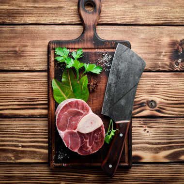 Ahşap kesme tahtasında Osso Buco yapmak için Dana şaft ve baharat. Üst görünüm. Metniniz için boş alan.