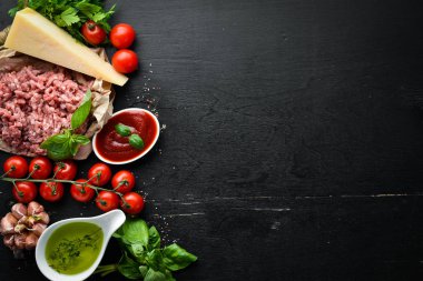 Pişirme sosu Bolognese için Malzemeler. Siyah bir arka plan üzerinde. Üst te. Metniniz için boş alan.