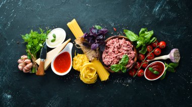 Makarna Bolonez için Malzemeler. Siyah bir arka plan üzerinde. Üst te. Metniniz için boş alan.