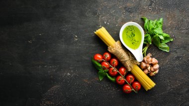 Kuru spagetti, soslar ve baharatlar. Siyah bir arka plan üzerinde. Üst te. Metniniz için boş alan.