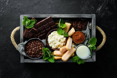 Tiramisu tatlısı. Tiramisu hazırlanması için Malzemeler. Üst te. Siyah taş bir arka plan üzerinde. Metniniz için boş alan.