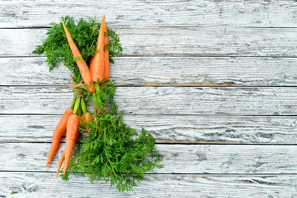 Beyaz ahşap arka planda taze havuç. Üst görünüm. Metniniz için boş alan.