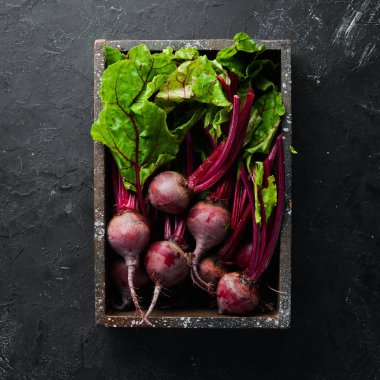 Siyah taş arka planda yaprakları ile taze pancar. Sağlıklı yiyecekler. Üst görünüm. Metniniz için boş alan.