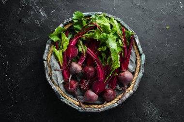 Siyah taş arka planda yaprakları ile taze pancar. Sağlıklı yiyecekler. Üst görünüm. Metniniz için boş alan.