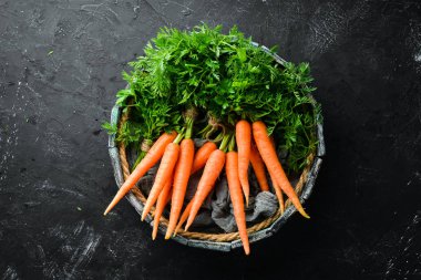 Siyah taş arka planda taze havuç. Üst görünüm. Metniniz için boş alan.