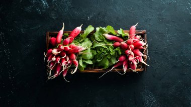 Siyah taş arka planda taze turp. Kırmızı turp üst görünümü.