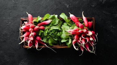 Siyah taş arka planda taze turp. Kırmızı turp üst görünümü.