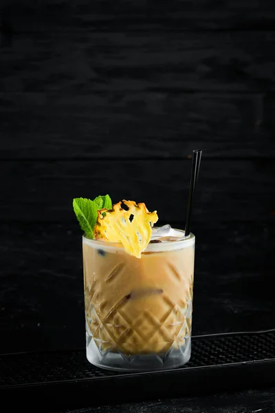Alcoholic cream-coffee cocktail in a glass. On a black background.