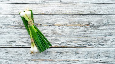 Beyaz ahşap arka planda yeşil soğan. Üst görünüm. Metin için boş alan.