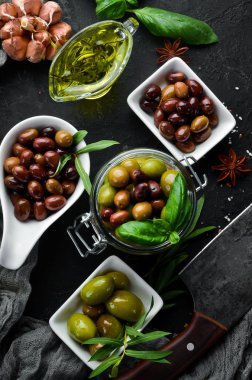 Zeytin, zeytinyağı, baharatlar ve Rustik arka plan üzerinde otlar. Üst te. Metniniz için boş alan.