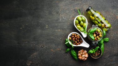 Zeytin, zeytinyağı, baharatlar ve Rustik arka plan üzerinde otlar. Üst te. Metniniz için boş alan.