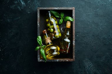 Zeytinyağı, zeytin ve baharatlar siyah taş zemin üzerinde. Üst te. Metniniz için boş alan.