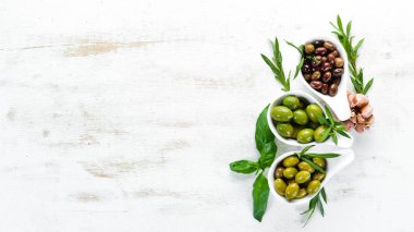 Bir kapta zeytin, zeytinyağı, baharat ve otlar. Üst te. Metniniz için boş alan.