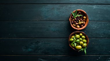 Bir kapta zeytin, zeytinyağı, baharat ve otlar. Üst te. Metniniz için boş alan.
