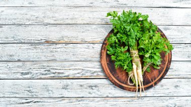 Beyaz ahşap arka plan üzerinde maydanoz kökü. Üst te. Metniniz için boş alan.