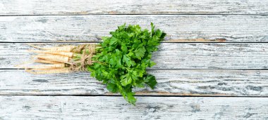 Beyaz ahşap arka plan üzerinde maydanoz kökü. Üst te. Metniniz için boş alan.