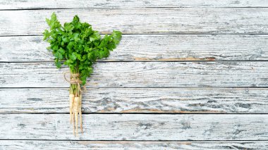 Beyaz ahşap arka plan üzerinde maydanoz kökü. Üst te. Metniniz için boş alan.