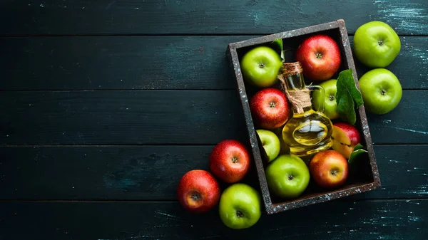 Apples and apple vinegar on the old background. Fruits. Top view. Free space for text.