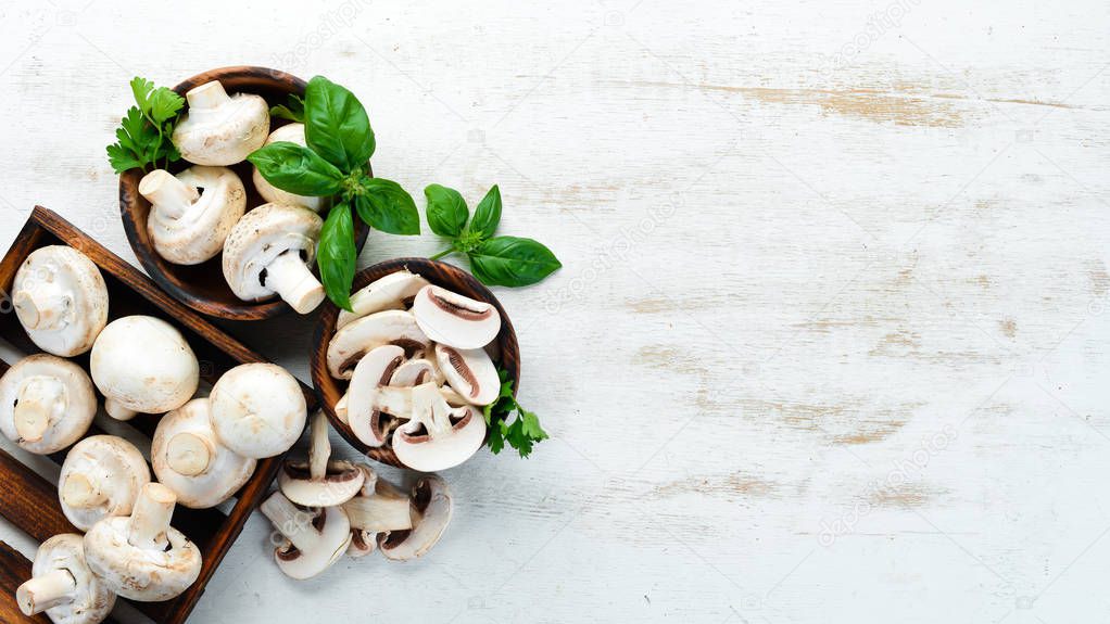 Champignons on a white cooking table. Mushrooms Top view. Free space for text.