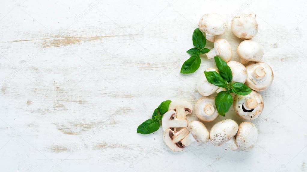 Champignons on a white cooking table. Mushrooms Top view. Free space for text.