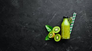 Yeşil Smoothies taze kivi ve kivi siyah bir arka plan Ahşap. Rustik tarz. Meyve. Üst te. Metin için boş alan.