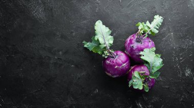 Mor kohlrabi lahanası. Siyah taş bir arka plan üzerinde. Üst te. Metniniz için boş alan.