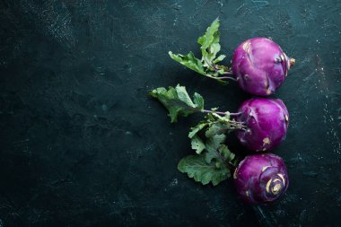 Mor kohlrabi lahanası. Siyah taş bir arka plan üzerinde. Üst te. Metniniz için boş alan.