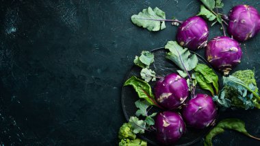 Mor kohlrabi lahanası. Siyah taş bir arka plan üzerinde. Üst te. Metniniz için boş alan.