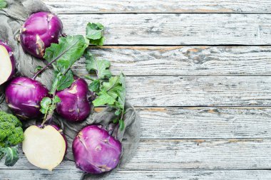 Ahşap arka plan üzerinde yeşil yaprakları ile Kohlrabi lahana. Üst te. Metniniz için boş alan.