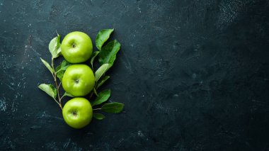 Siyah bir arka plan üzerinde yeşil yaprakları ile Taze yeşil elma. Meyve. Üst te. Metin için boş alan.