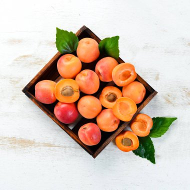 Bir kutuda yeşil yaprakları ile taze kayısı. Rustik tarz. Üst te. Metniniz için boş alan.